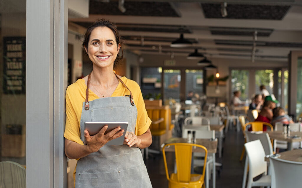 Small business owner at entrance looking at camera